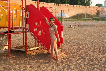 Русская девушка с красивыми сиськами гуляет голышом на детской площадке