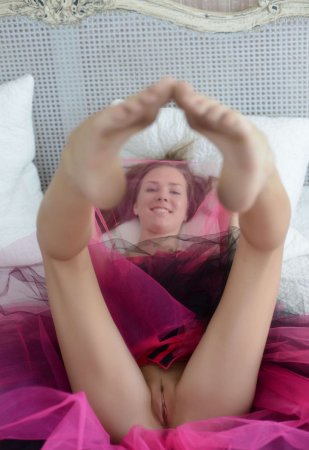 Спортивная девушка в ярком розовом платье в постели