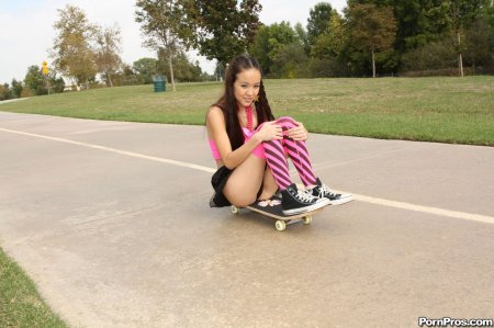 Худенькая азиатка в короткой юбке катается на скейте и показывает трусики